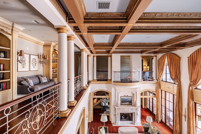 hallway with crown molding, hardwood / wood-style flooring, coffered ceiling, and ornate columns