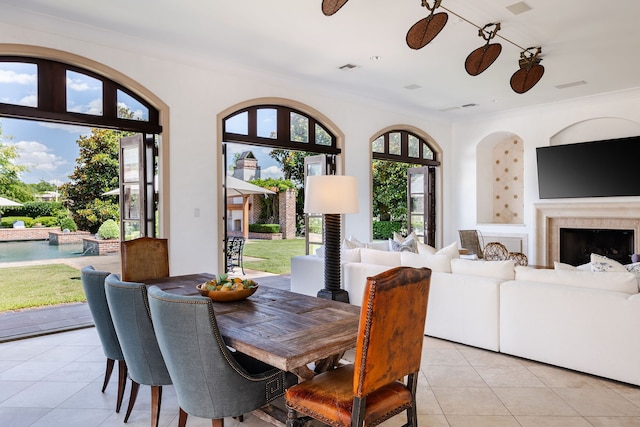 tiled dining space with ornamental molding, ceiling fan, and a wealth of natural light