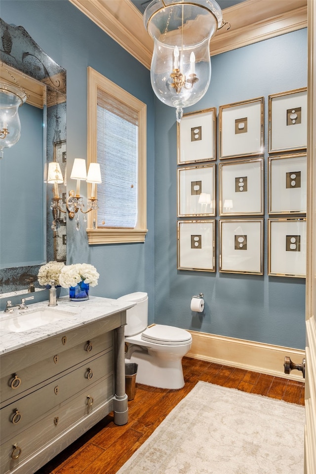 bathroom featuring ornamental molding, hardwood / wood-style flooring, vanity, and toilet