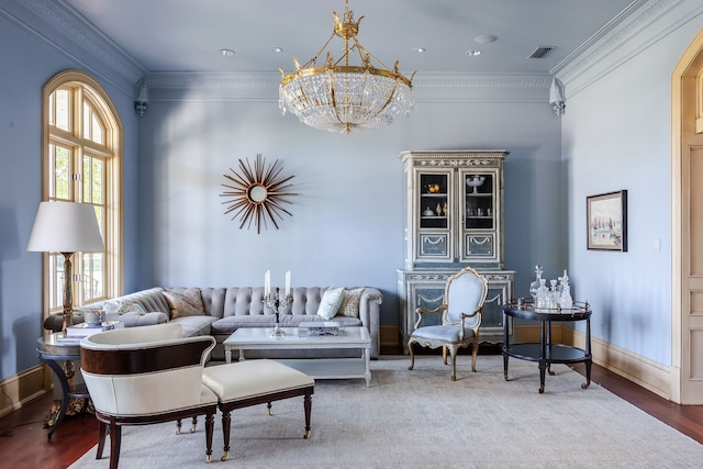 living room with wood-type flooring, a chandelier, and ornamental molding