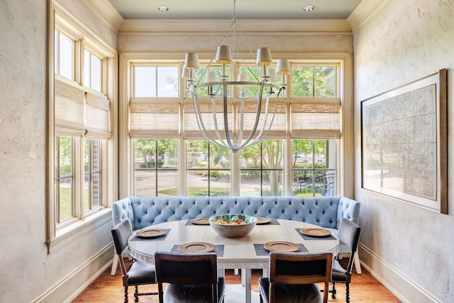 dining space featuring a notable chandelier, hardwood / wood-style floors, a healthy amount of sunlight, and crown molding