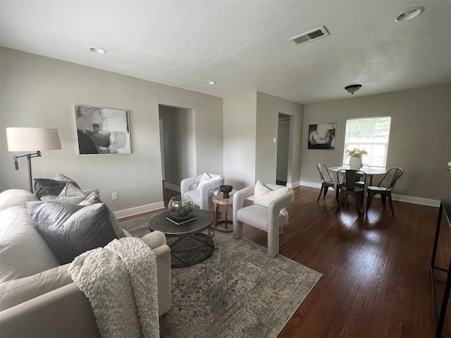 living room featuring a textured ceiling and dark hardwood / wood-style flooring