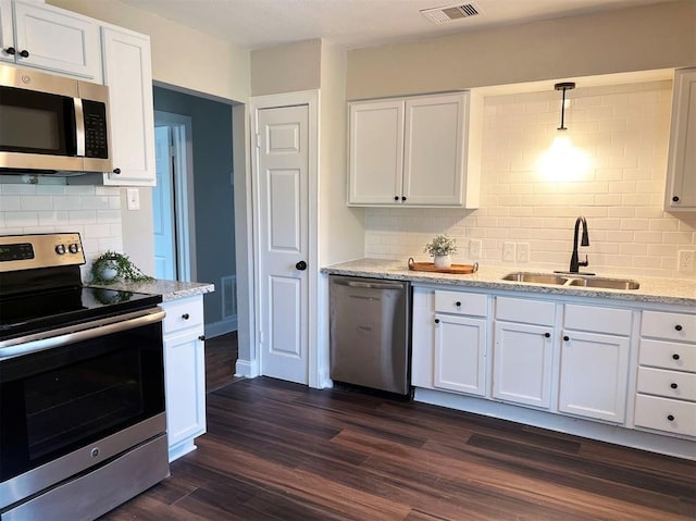 kitchen featuring sink, decorative light fixtures, dark wood-type flooring, white cabinetry, and stainless steel appliances