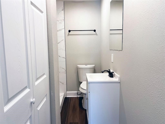 bathroom featuring a shower, vanity, toilet, and hardwood / wood-style flooring