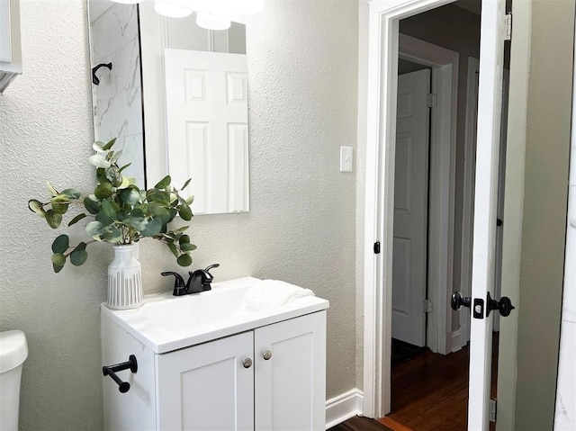 bathroom with wood-type flooring, vanity, toilet, and a shower