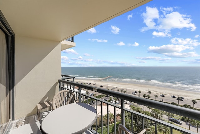 balcony featuring a beach view and a water view