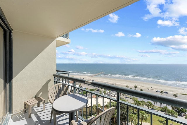 balcony featuring a view of the beach and a water view