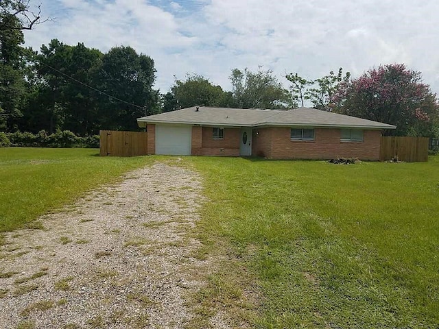 ranch-style home featuring a front lawn and a garage