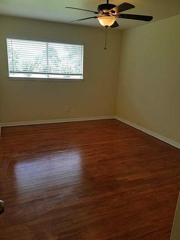 unfurnished room featuring ceiling fan, dark hardwood / wood-style flooring, and a wealth of natural light