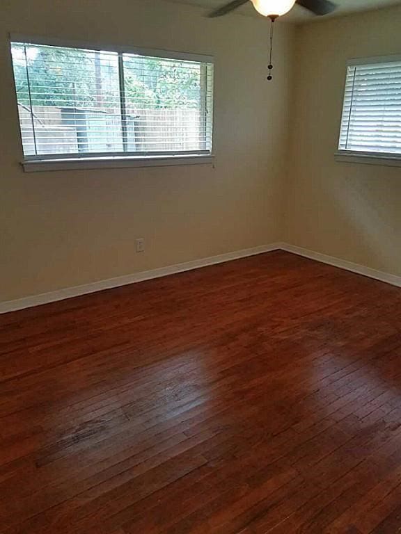 spare room with ceiling fan and dark hardwood / wood-style flooring