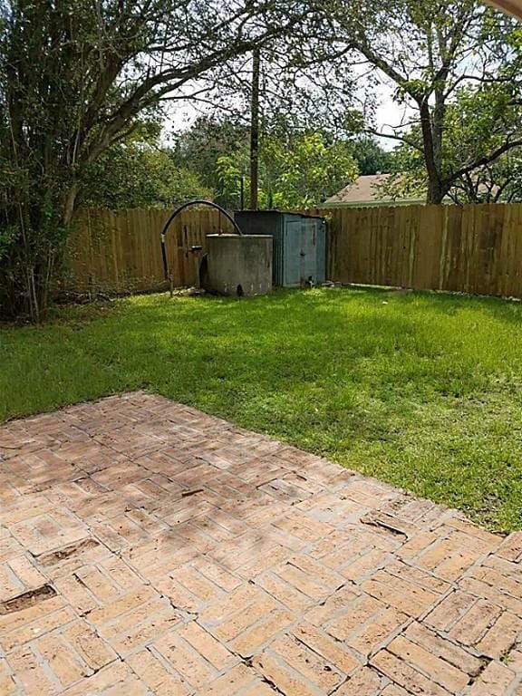 view of yard with a storage unit and a patio