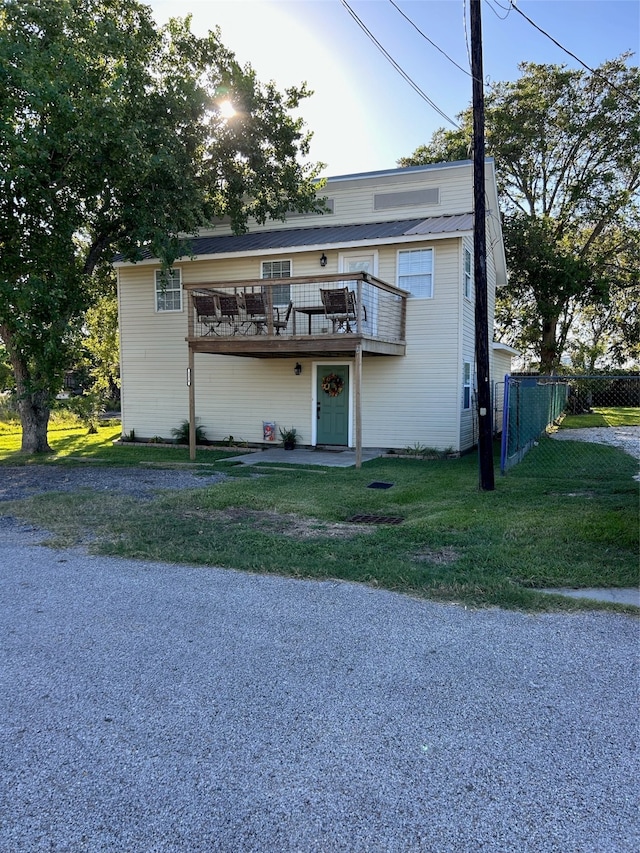 view of front of property featuring a front yard and a deck