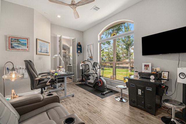 exercise area featuring ceiling fan and light hardwood / wood-style flooring