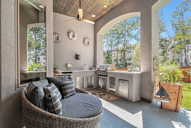 view of patio / terrace featuring ceiling fan, a grill, and an outdoor kitchen