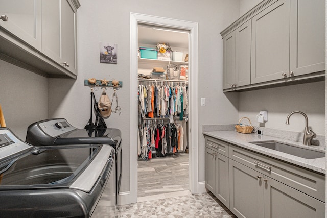 washroom with cabinets, sink, and washer and dryer