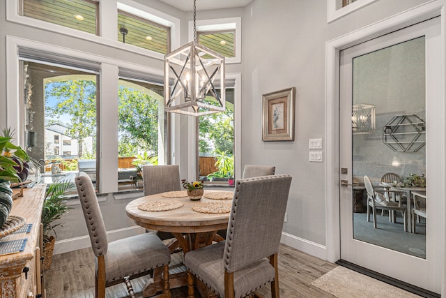 dining space featuring wood-type flooring and a chandelier