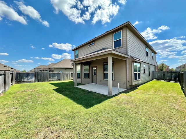 rear view of property with a yard and a patio area