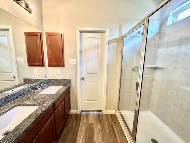 bathroom with wood-type flooring, vanity, and a shower with door