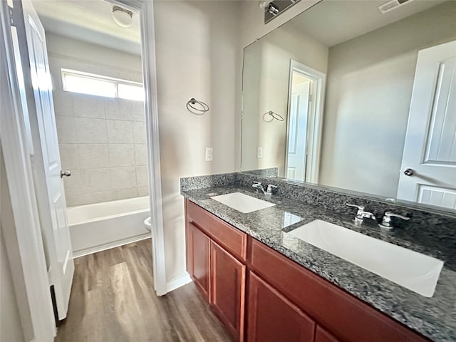 full bathroom with wood-type flooring, vanity, toilet, and tiled shower / bath