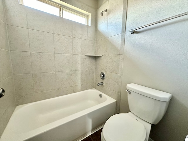 bathroom with tiled shower / bath and toilet