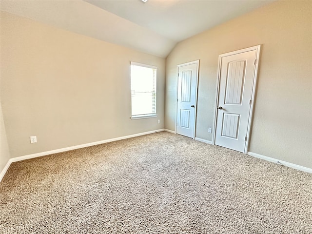 unfurnished bedroom with lofted ceiling and carpet floors