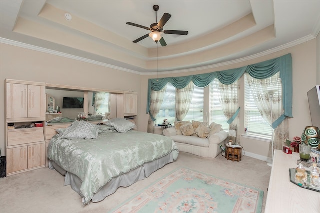 bedroom with ornamental molding, a tray ceiling, light carpet, and ceiling fan