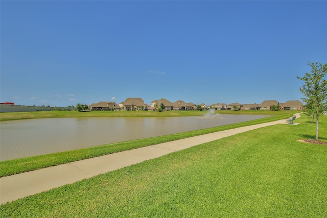 view of home's community with a yard and a water view