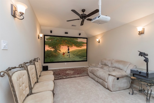 carpeted home theater room featuring ceiling fan and vaulted ceiling