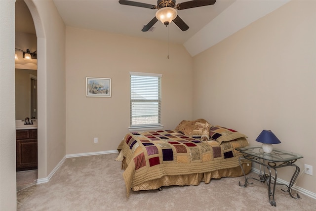 bedroom featuring connected bathroom, lofted ceiling, ceiling fan, and light colored carpet