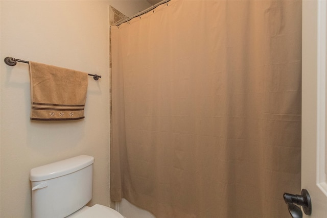 bathroom with toilet and a shower with curtain