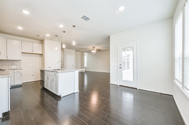 kitchen with hanging light fixtures, an island with sink, white cabinets, dishwasher, and ceiling fan