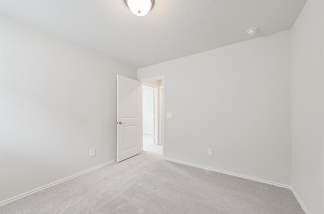 unfurnished room featuring light carpet