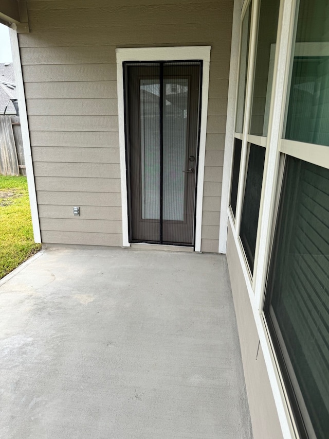 view of exterior entry featuring a patio area