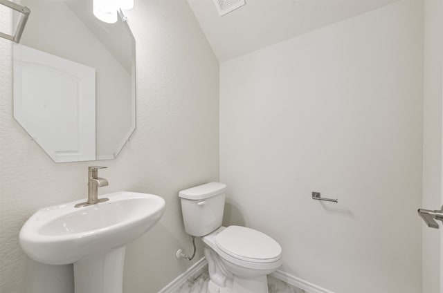 bathroom featuring vaulted ceiling, sink, and toilet