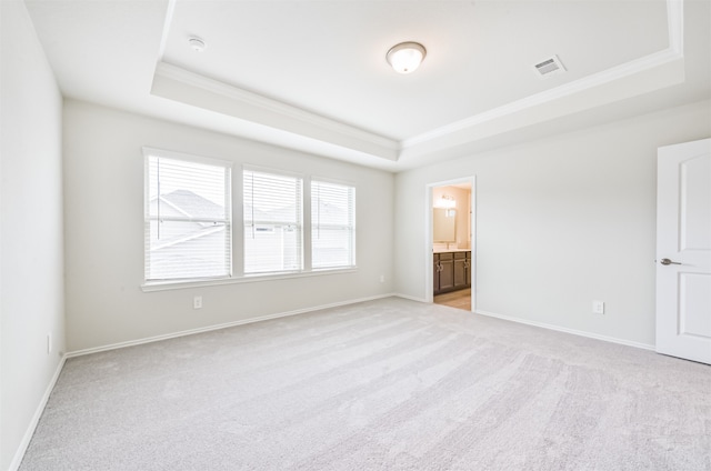 carpeted spare room with a tray ceiling and crown molding