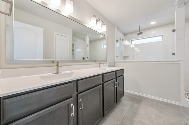 bathroom featuring a tile shower, tile patterned floors, and vanity