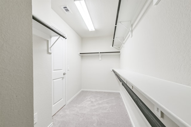 spacious closet with light colored carpet