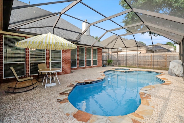 view of swimming pool with a patio, glass enclosure, and an in ground hot tub