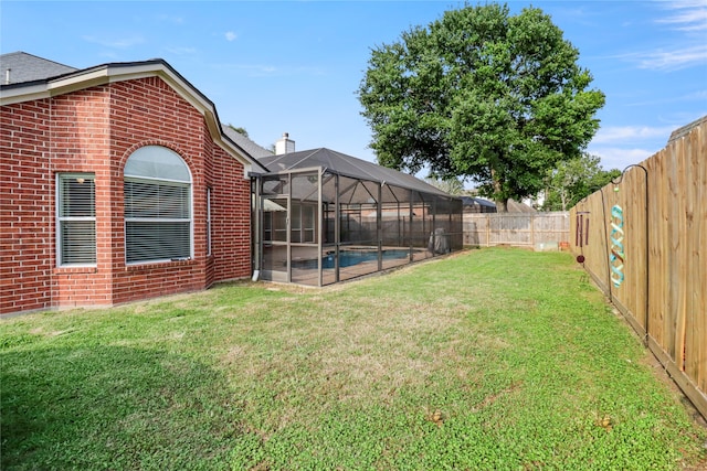 view of yard featuring a fenced in pool and glass enclosure