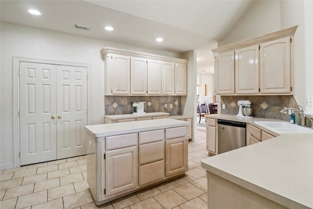 kitchen featuring tasteful backsplash, a kitchen island, dishwasher, lofted ceiling, and sink