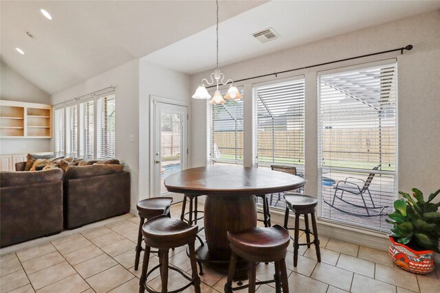 tiled dining area featuring lofted ceiling and a chandelier