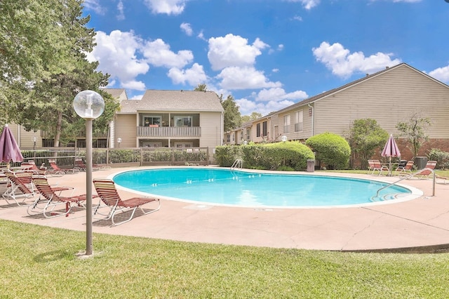 view of swimming pool with a patio and a yard