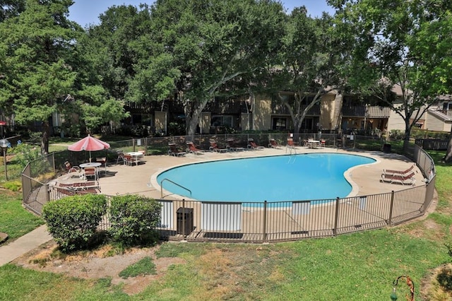 view of pool with a patio and a yard