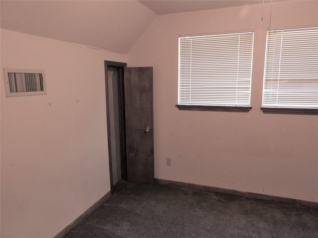 carpeted spare room featuring vaulted ceiling