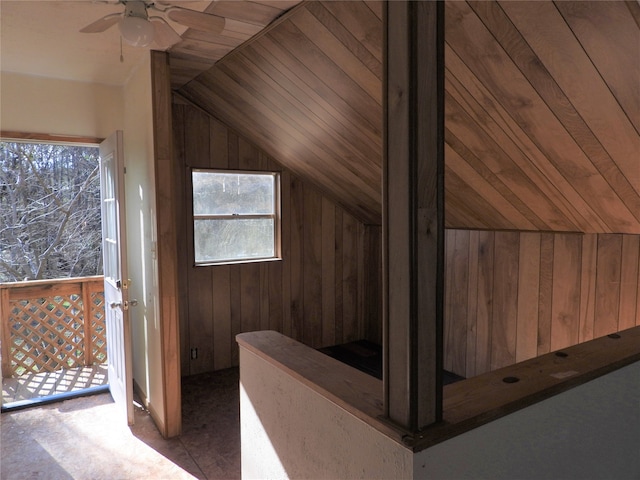 additional living space featuring ceiling fan, wooden walls, and lofted ceiling