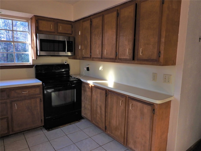 kitchen featuring light tile patterned flooring and black electric range oven