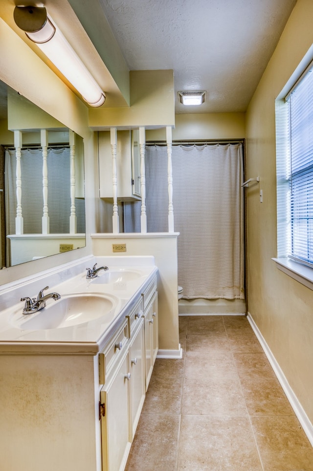 bathroom with tile patterned floors, a textured ceiling, vanity, and toilet