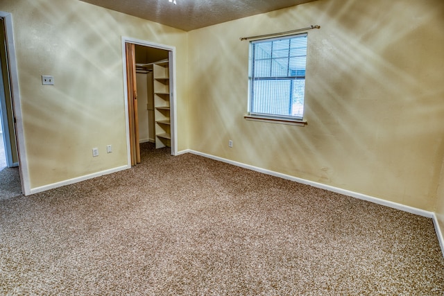 carpeted spare room with a textured ceiling