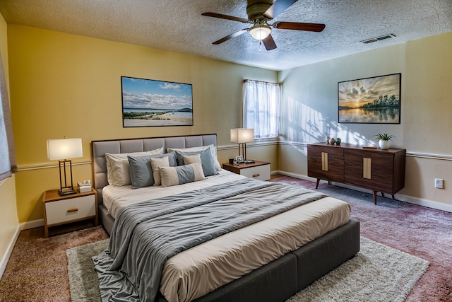 carpeted bedroom featuring ceiling fan and a textured ceiling