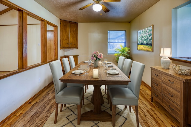 dining room featuring light hardwood / wood-style flooring, a textured ceiling, and ceiling fan